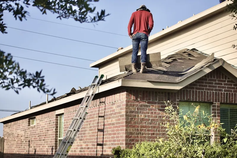 Professional roofer working on a residential roof in Marlboro Village